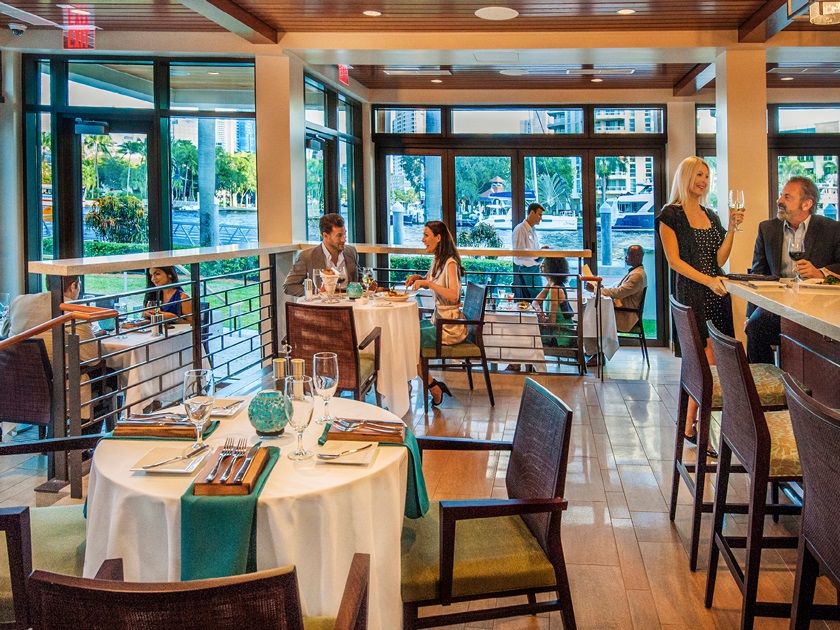 Several guests inside a restaurant enjoying their dinner and wine.